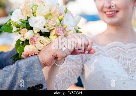 Bride puts the ring on the finger of the groom. Hands of groom and bride with rings Hands of groom and bride with rings. Stock Photo