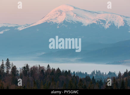 Early morning spring Carpathian mountains plateau landscape with snow-covered ridge tops in far, Ukraine. Stock Photo