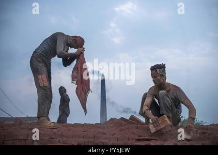 Narayanganj, Narayanganj, Bangladesh. 17th Mar, 2018. Men are seen working at the Brick field.Bangladesh is one of the developing country in recent days, where the industries, houses and mills everything is growing rapidly, in this era the demand for the bricks is too high and yet people are still making bricks in a traditional way and mostly the workers, who work in these brick factories are brought from the north parts of Bangladesh. These are internal migrated workers and they come hoping to make more money than in their villages, generally in every brick factory, the authorities comprom Stock Photo