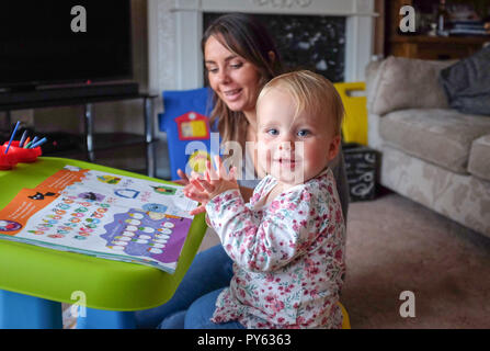Young two year old baby toddler girl with her mother playing at home Stock Photo
