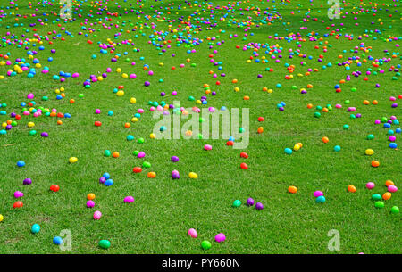 An Easter egg hunt with colorful plastic eggs on a green lawn Stock Photo