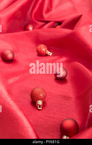 Christmas balls on rich red wavy fabric. Stock Photo