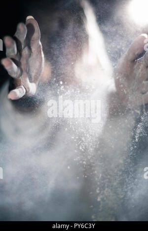 Young woman clapping dust in her hands Stock Photo