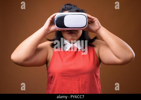 Beautiful overweight Asian woman using virtual reality VR glasses Stock Photo