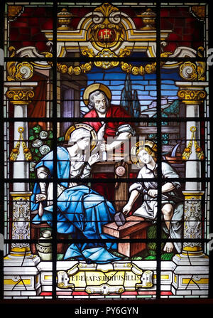 Porto, Portugal - March 23, 2015: Stained glass window from  church of Lapa representing a scene of the holy family, seeing Jesus learning carpentry,  Stock Photo