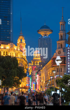 Crowd of People against the Shanghai skyline along a busy crowded Nanjing Road West, Shanghai, China, Asia at night Stock Photo