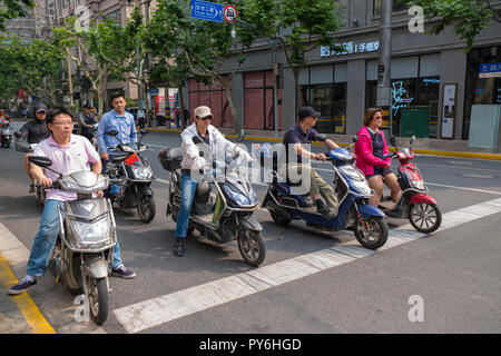 Group of people riding scooters in a street in Shanghai, China, Asia Stock Photo