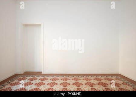 Blank, white wall with niche and decorated tiled floor in a renovated interior Stock Photo