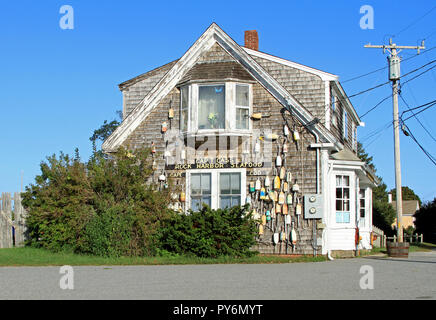 Wooden buoys hanging from shingled exterior side wall of Cap't Cass Rock Harbor Seafood Restaurant on Cape Cod, Orleans, Massachusetts Stock Photo