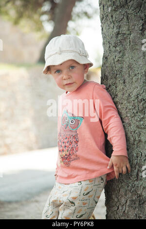 Lovely cute little baby 2-4 years old girl in pink t-shirt and white in hot weather of summer in Croatia holiday. Stock Photo