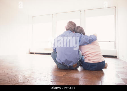 Senior couple hugging in an empty apartment, USA Stock Photo