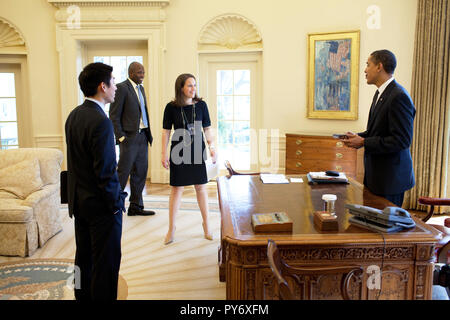President Barack Obama jokes with Special Assistant Eugene Kang,  Personal Secretary Katie, Johnson and Personal Aide  Reggie Love in the Oval Office 3/5/09.  Official White House Photo by Pete Souza Stock Photo