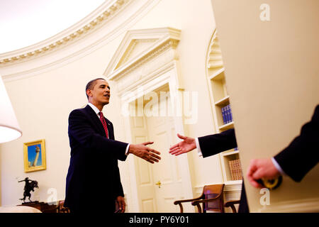 President Barack Obama shakes hands with a guest entering the Oval Office, May 20, 2009. (Official White House photo by Pete Souza)  This official White House photograph is being made available for publication by news organizations and/or for personal use printing by the subject(s) of the photograph. The photograph may not be manipulated in any way or used in materials, advertisements, products, or promotions that in any way suggest approval or endorsement of the President, the First Family, or the White House. Stock Photo