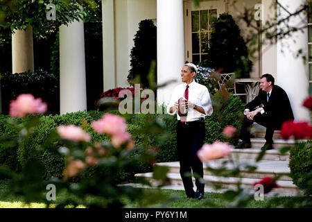 President Barack Obama throws a football to a staff member in the Rose Garden, while White House Trip Director Marvin Nicholson watches, May 22, 2009.  (Official White House Photo by Pete Souza)  This official White House photograph is being made available for publication by news organizations and/or for personal use printing by the subject(s) of the photograph. The photograph may not be manipulated in any way or used in materials, advertisements, products, or promotions that in any way suggest approval or endorsement of the President, the First Family, or the White House. Stock Photo