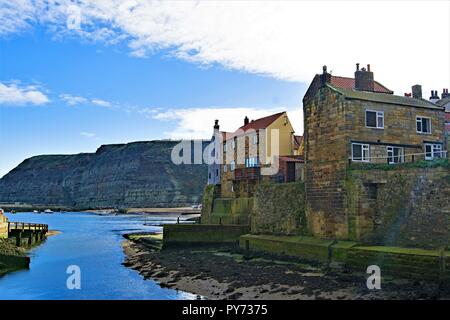 Capturing an idyllic sunny autumn day along the picturesque harbour of the North Yorkshire coast village of Staithes. Stock Photo