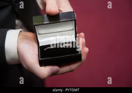wedding rings in ring box held in best mans hand right before the wedding ceremony Stock Photo