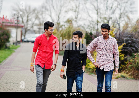 Three indian guys students friends walking on street. Stock Photo