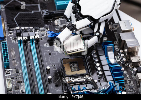 Close-up Of A Robotic Hand Placing Processor Chip In Motherboard Stock Photo