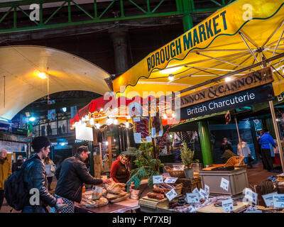 Borough Market British Meat Charcuterie late night winter shopping at specialist Charcuterie British meat produce stall lit at dusk Southwark London Stock Photo