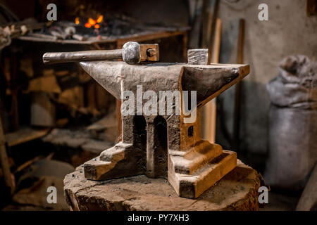 Old blacksmiths hammer on anvil in workshop read to be used for forging iron. Stock Photo