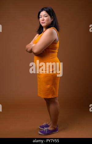 Full length profile view of overweight woman with arms crossed Stock Photo