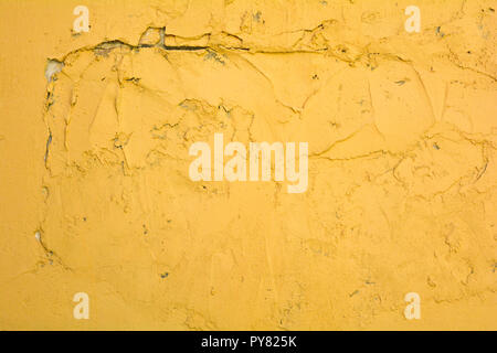 Old and weathered orange yellow painted rough concrete wall. Vibrant color plaster Stock Photo