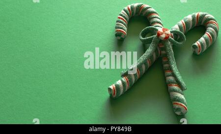 candy canes tied with bow on green background with writing space Stock Photo
