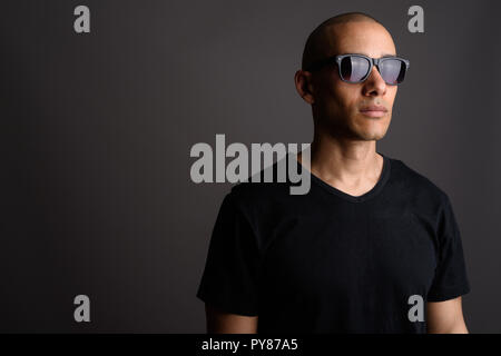 Handsome bald man wearing black shirt and sunglasses Stock Photo