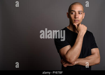 Handsome bald man wearing black shirt and thinking Stock Photo