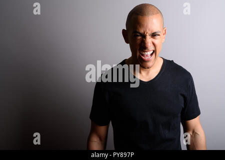 Handsome bald man looking angrily at camera while screaming Stock Photo