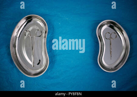 top view of medical instruments in the tray, disposable gloves on blue background. health, longevity Stock Photo