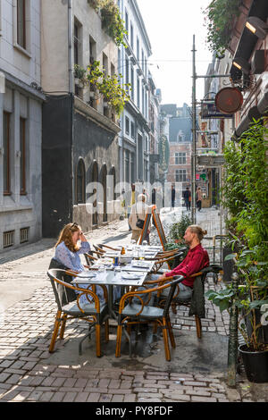 Young couple eating outdoors at street restaurant in old town, Brussels Belgium Stock Photo