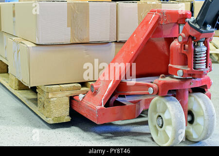 Hand pallet truck with cardboard boxes close up. Stock Photo