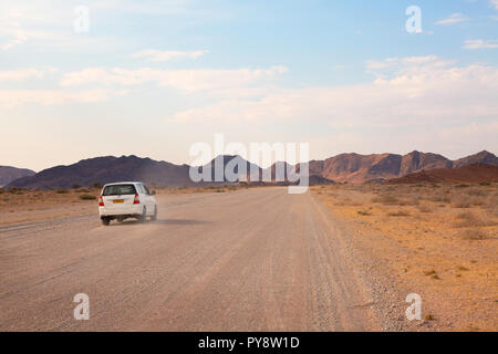 Namibia travel - A car driving on a gravel road through the Namib desert, Namibia Africa Stock Photo