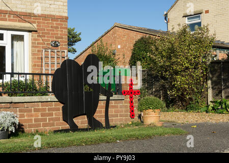 Soldier silhouette and poppies in the shape of a cross outside a house in the village of Quinton, Northamptonshire, UK Stock Photo