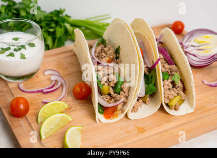 Mexican tacos with pork, pepper and tomatoes on the white wooden background. Shallow depth of field. Stock Photo