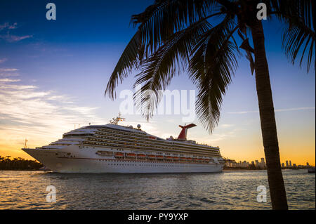 MIAMI - CIRCA AUGUST, 2018: The Carnival Victory Cruise ship passes in front of the city skyline during a sunset departure. Stock Photo
