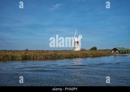 A disused windmill next to the River Thurne on a clear autumn day Norfolk Broads, Norfolk, England, UK Stock Photo