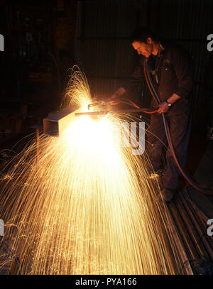 Male welder at work in his engineering workshop oxyacetylene welding, cutting and fabricating metal components Stock Photo