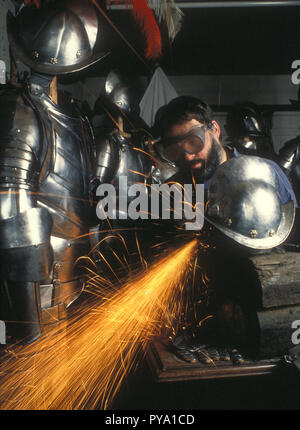 A skilled armourer craftsman puts the finishing touches to a replica suit of armour and morrion, in his workshop in Birmingham, UK Stock Photo