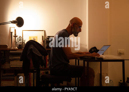Man Working at Desk at Home Stock Photo