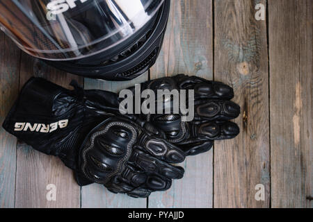 Fryazino, Russia - 06 18 2018: motorcycle rider accessories. helmet and gloves on wooden table, top view Stock Photo