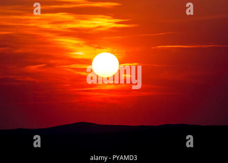 Beautiful colorful sunset with dramatic clouds and sun shining over mountains. Shot in Croatia. Stock Photo