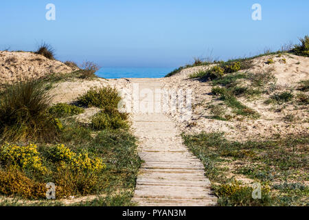 Wooden path through the dunes in a mediterranean beach Stock Photo