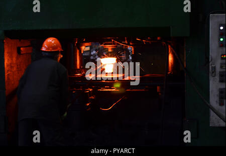 Industrial Worker at the factory welding closeup. Hot iron in smeltery held by a worker. Smelting of the metal in the foundry. Heavy forging steelmaki Stock Photo