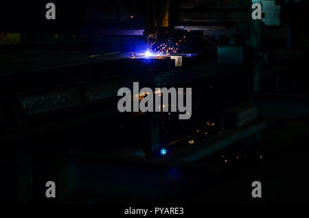 Worker cutting steel pipe using metal torch and install roadside fence. Plasma cutting. Laser equipment management and plant manufacturing metal struc Stock Photo