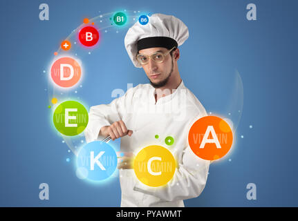 Handsome cook with kitchen instruments and vitamin concept Stock Photo ...