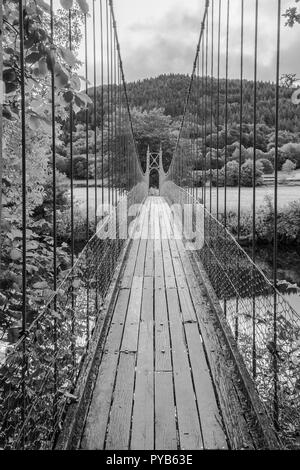Sappers suspension bridge over the River Conwy built in 1930 and a prominent landmark in the village of Betws-y-Coed in North Wales. In Black and Whit Stock Photo