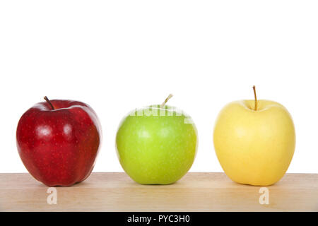 One red, green and yellow apples on a light wood table isolated on white background Stock Photo