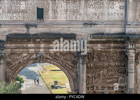 Two tourist, seen through the Arch of Septimius Severus,  explore the Roman Forum , Rome, Italy. Stock Photo